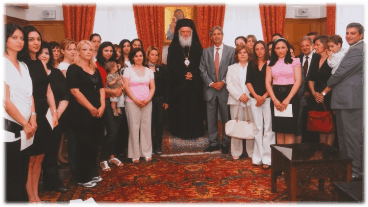 Ο αρχιεπίσκοπος Αθηνών και Πάσης Ελλάδος Ιερώνυμος εν μέσω μελών οικογένειας ευεργετών και θυγατέρων ναυτικών, που παρέλαβαν γαμήλιο δώρο (2010)
